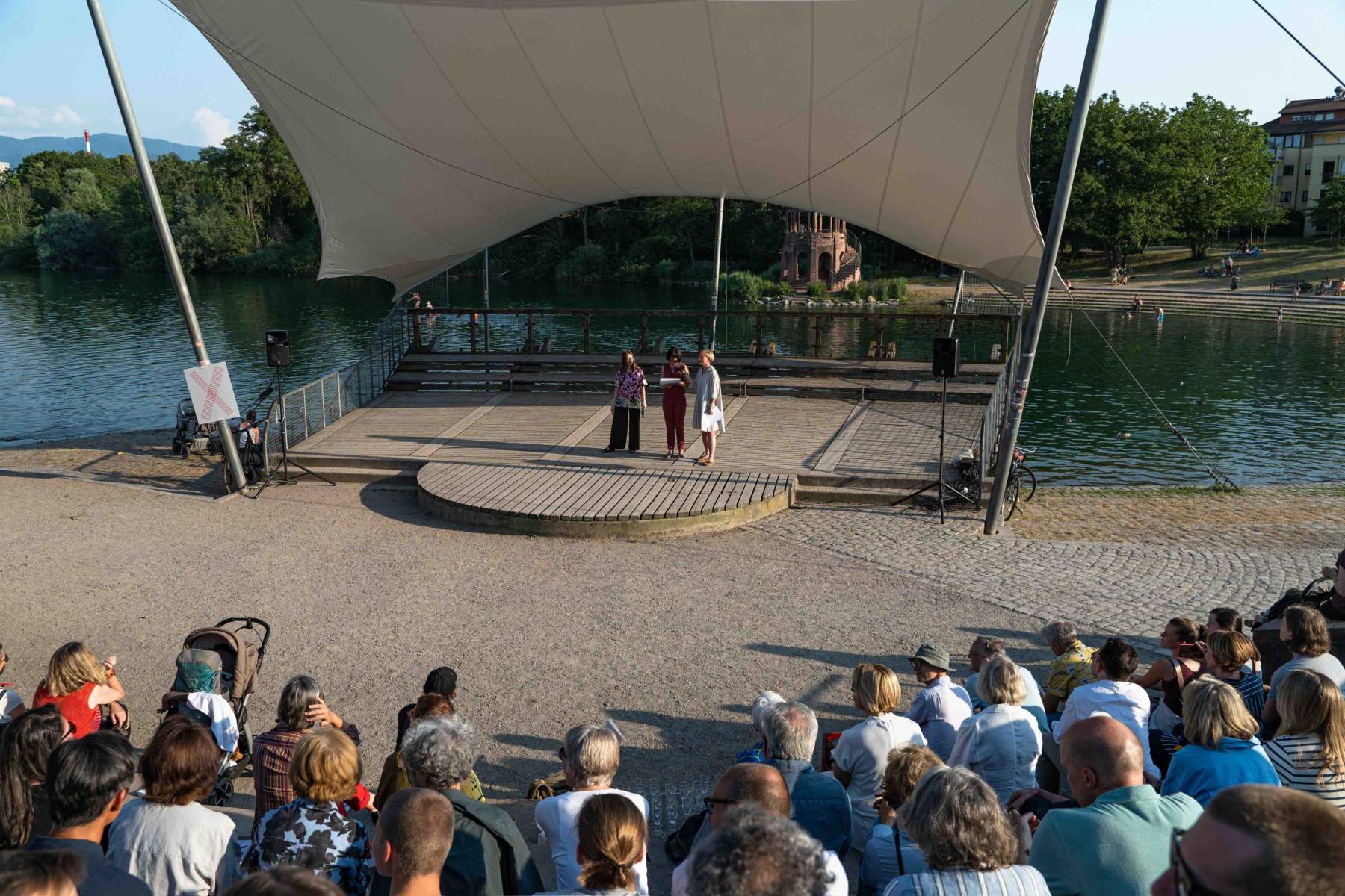 Felicia Maier (Kulturamtsleiterin der Stadt Freiburg), Julia Galandi-Pascual (2. Vorstandsvorsitzende, Perspektiven für Kunst in Freiburg e.V.) und Paula Kommoss (Künstlerische Leiterin, Biennale für Freiburg 2) auf der Seebühne im Seepark.
Foto: Sévérine Kpoti, © Biennale für Freiburg 2